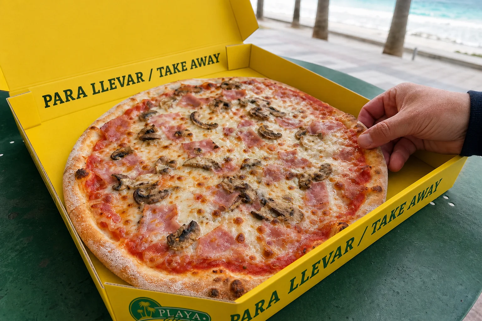 Pizza artesanal en la caja amarilla para llevar de Playa Verde